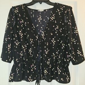 A.n.a black floral-patterned, lace-up crop top with a ruffled hem.